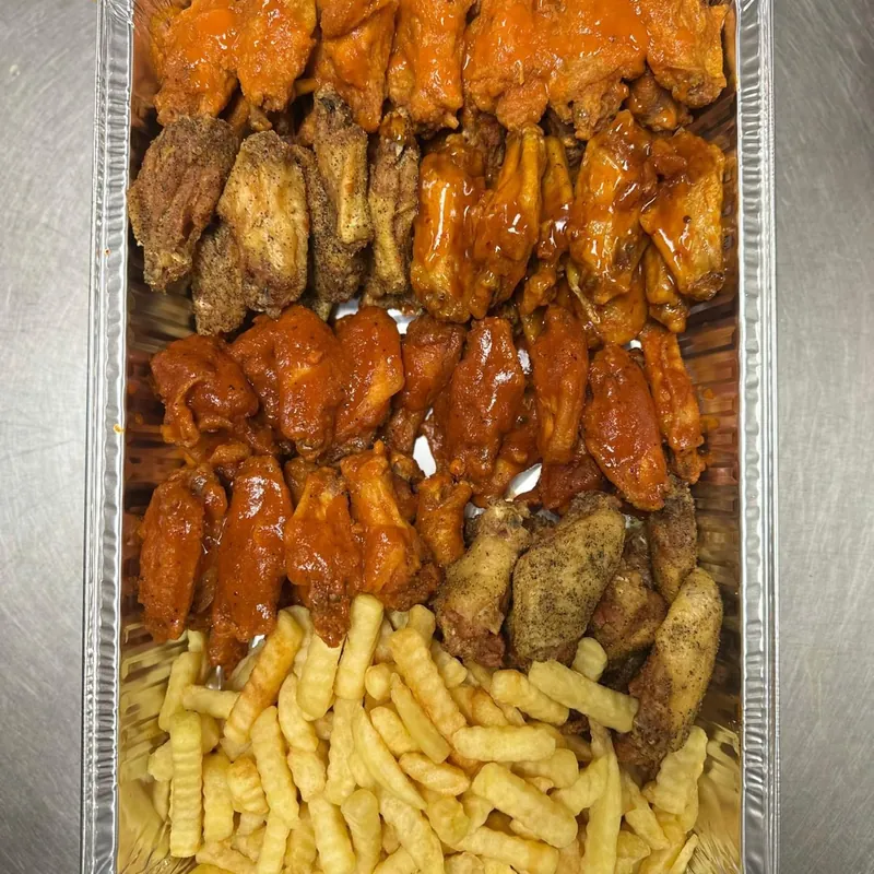 A party tray of wings in four flavours with fries